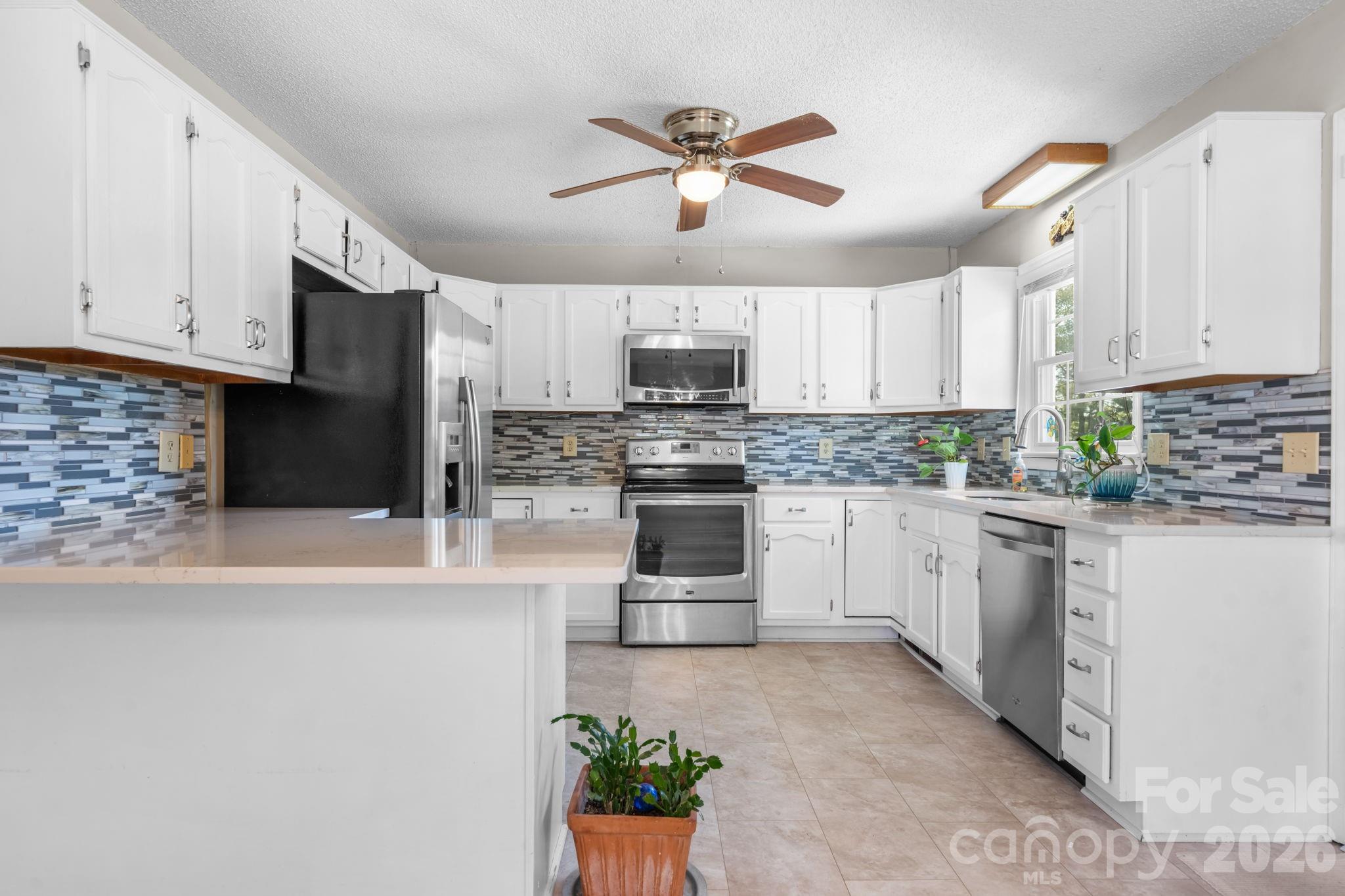 65 Pinewood Road Granite Falls, NC 28630 - Photo 14 of 42 a kitchen with granite countertop a stove sink and cabinets