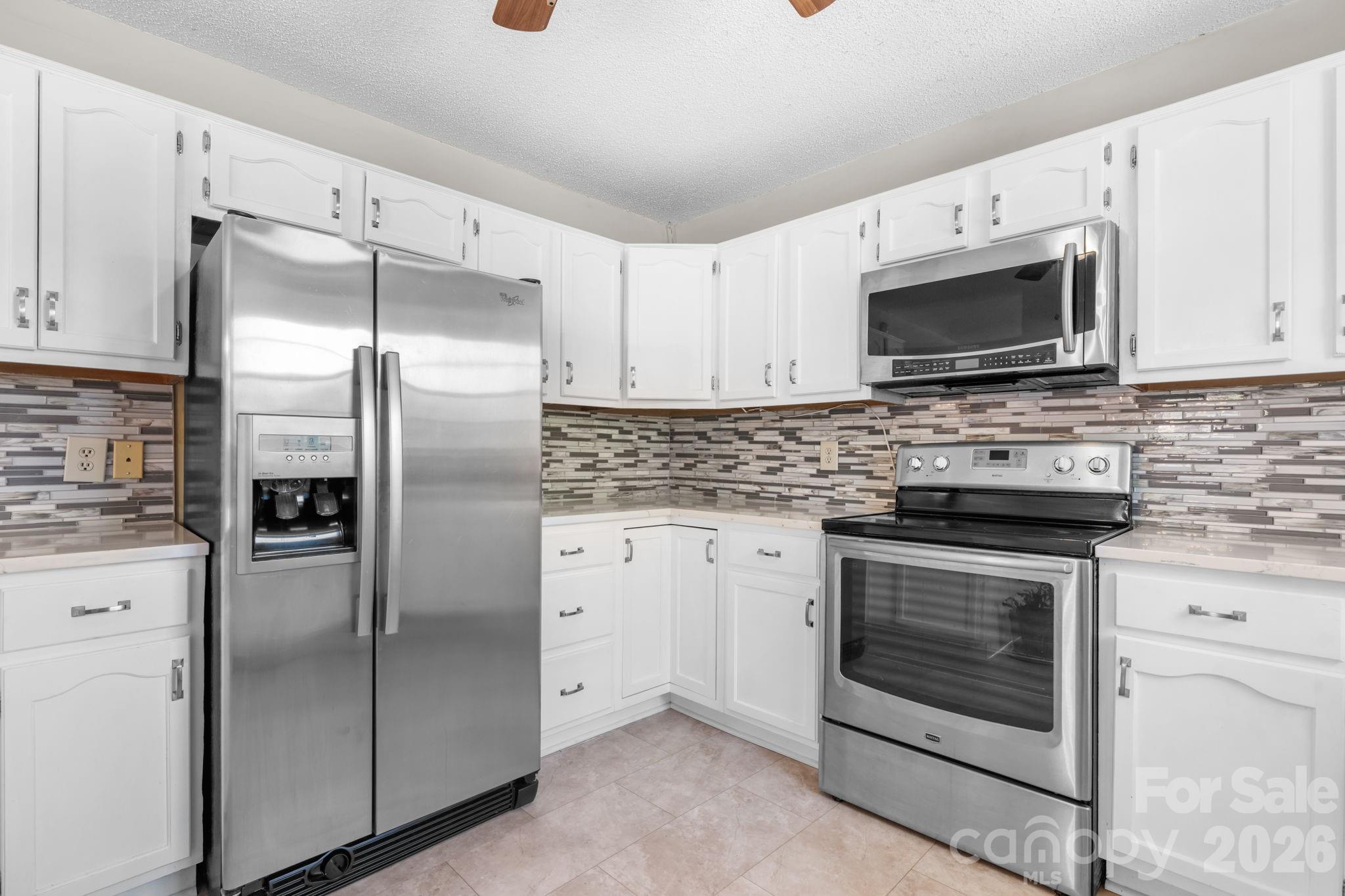 65 Pinewood Road Granite Falls, NC 28630 - Photo 16 of 42 a kitchen with stainless steel appliances granite countertop a refrigerator stove and microwave