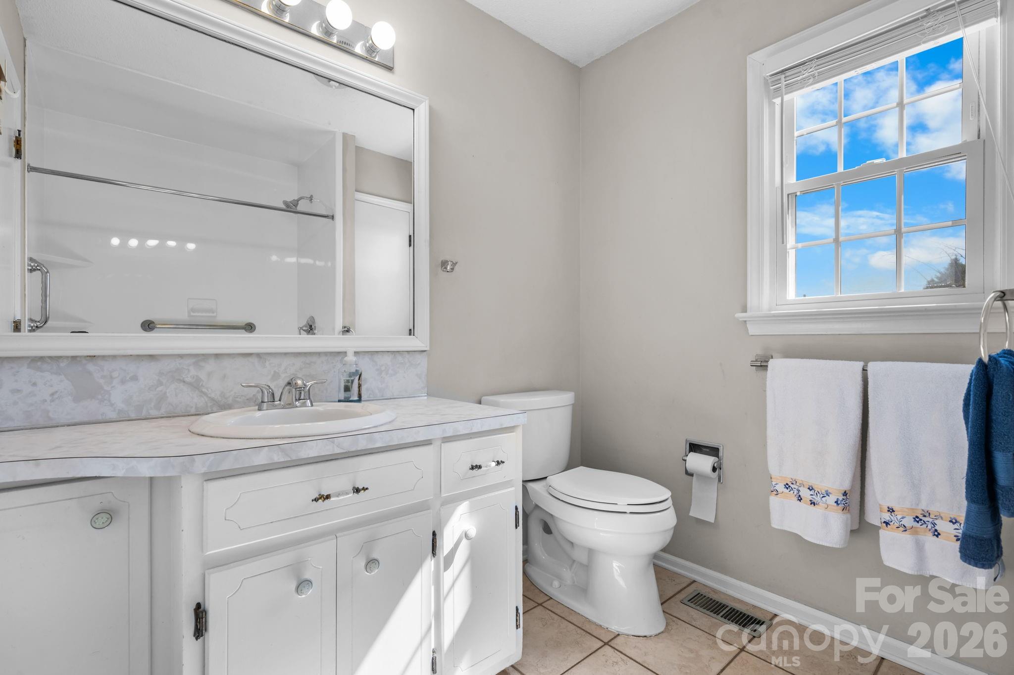 65 Pinewood Road Granite Falls, NC 28630 - Photo 27 of 42 a bathroom with a granite countertop toilet sink and a mirror