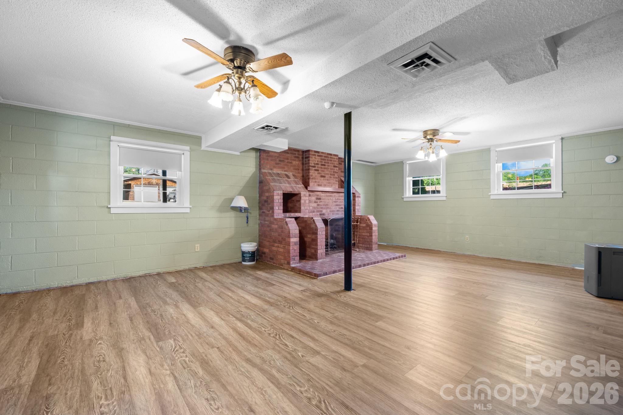 65 Pinewood Road Granite Falls, NC 28630 - Photo 30 of 42 an empty room with wooden floor chandelier fan and windows