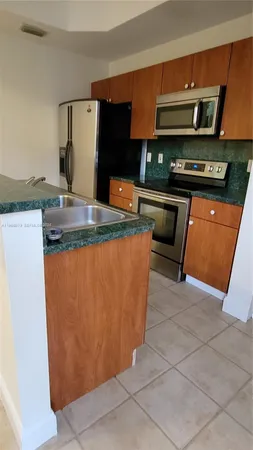 a kitchen with granite countertop a stove top oven and cabinets