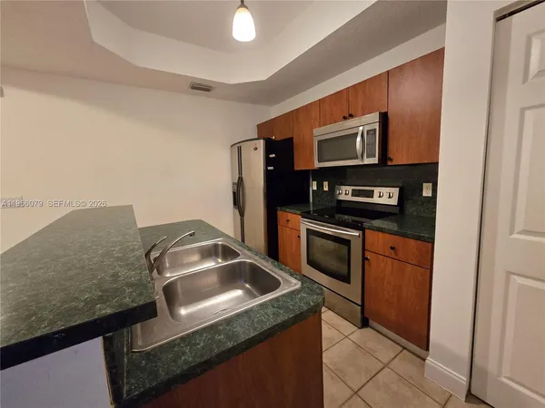 a kitchen with stainless steel appliances granite countertop a sink stove and microwave