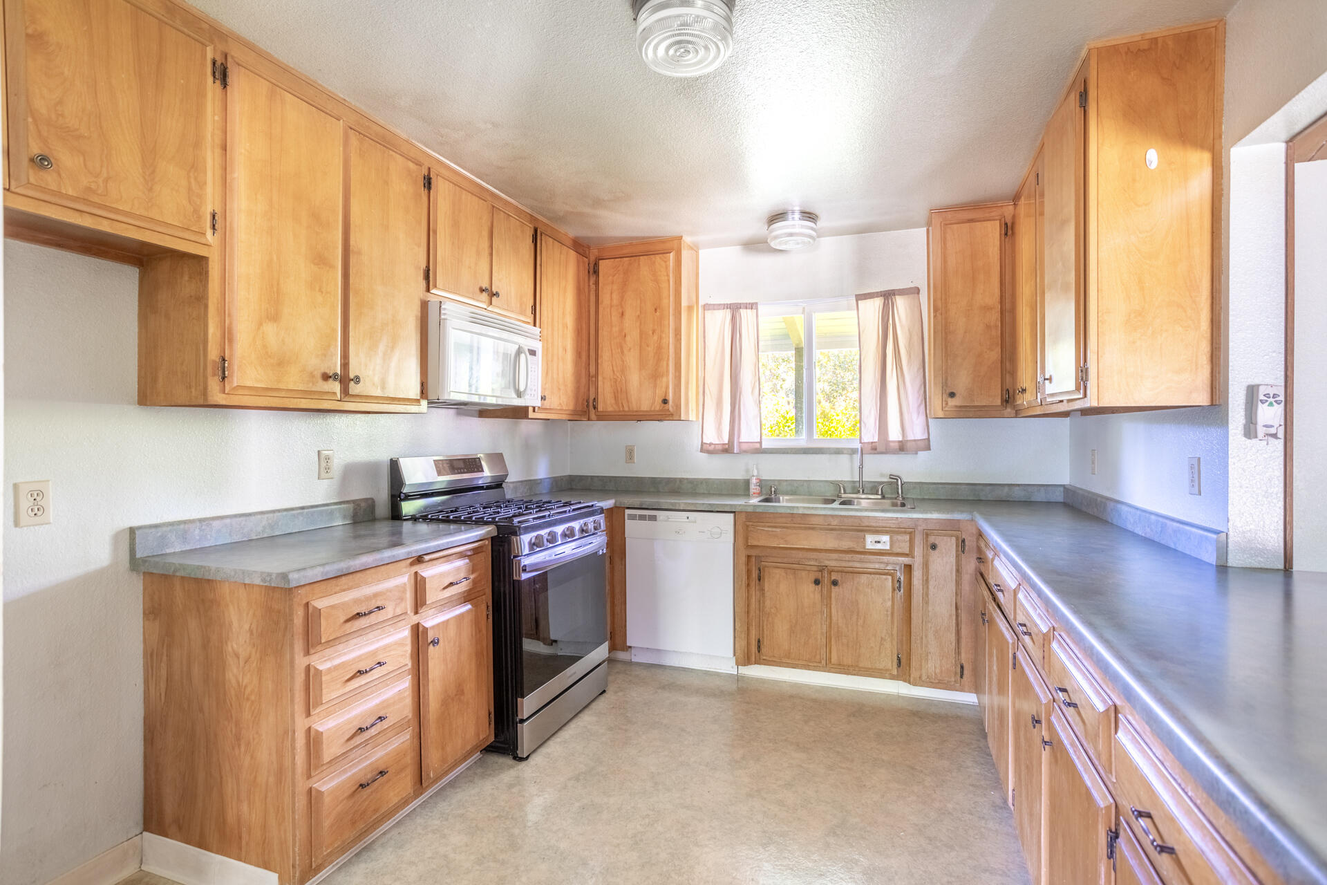 8415 Valley View Road Redding, CA 96001 - Photo 13 of 31 a kitchen with stainless steel appliances granite countertop a sink stove and cabinets
