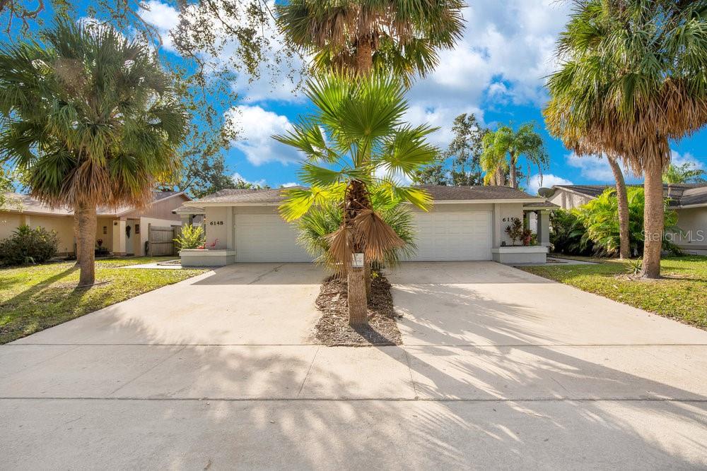 a view of a house with garden and a tree
