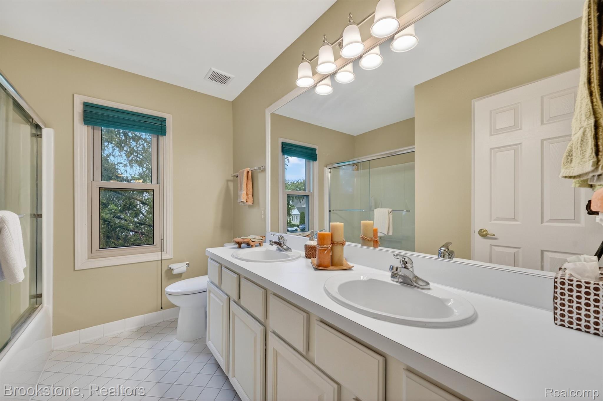 4054 Calumet Drive Rochester, MI 48306 - Photo 24 of 44 Full bathroom featuring double vanity, bath / shower combo with glass door, and light tile patterned floors
