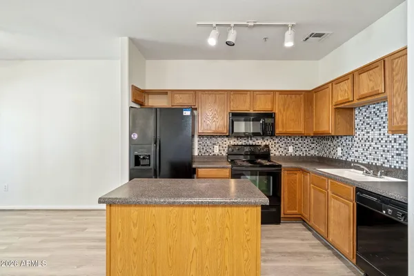 a kitchen with stainless steel appliances granite countertop a sink and a stove