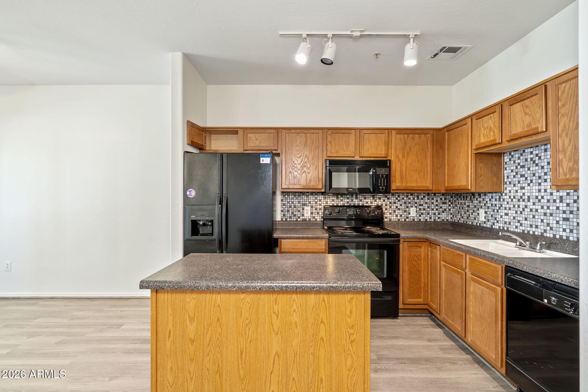 1718 West Colter Street, Unit 126 Phoenix, AZ 85015 - Photo 7 of 29 a kitchen with stainless steel appliances granite countertop a sink and a stove