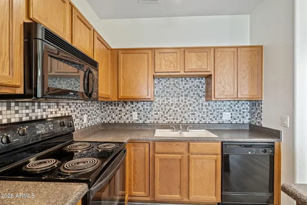 a kitchen with granite countertop a stove sink and cabinets
