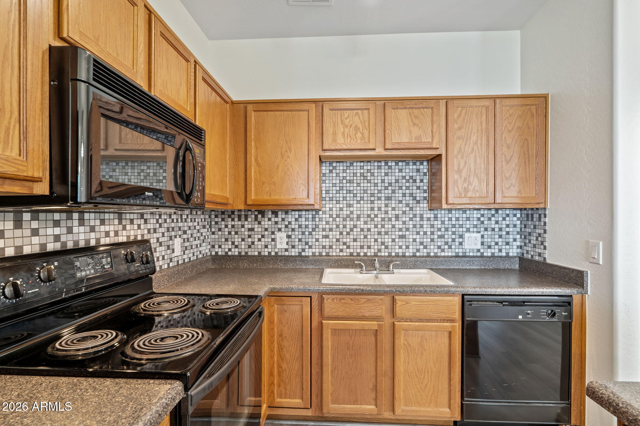 1718 West Colter Street, Unit 126 Phoenix, AZ 85015 - Photo 8 of 29 a kitchen with granite countertop a stove sink and cabinets