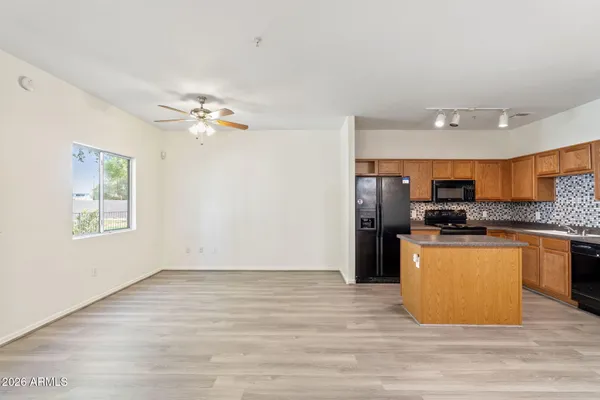 a view of kitchen with stainless steel appliances granite countertop a refrigerator stove top oven and sink
