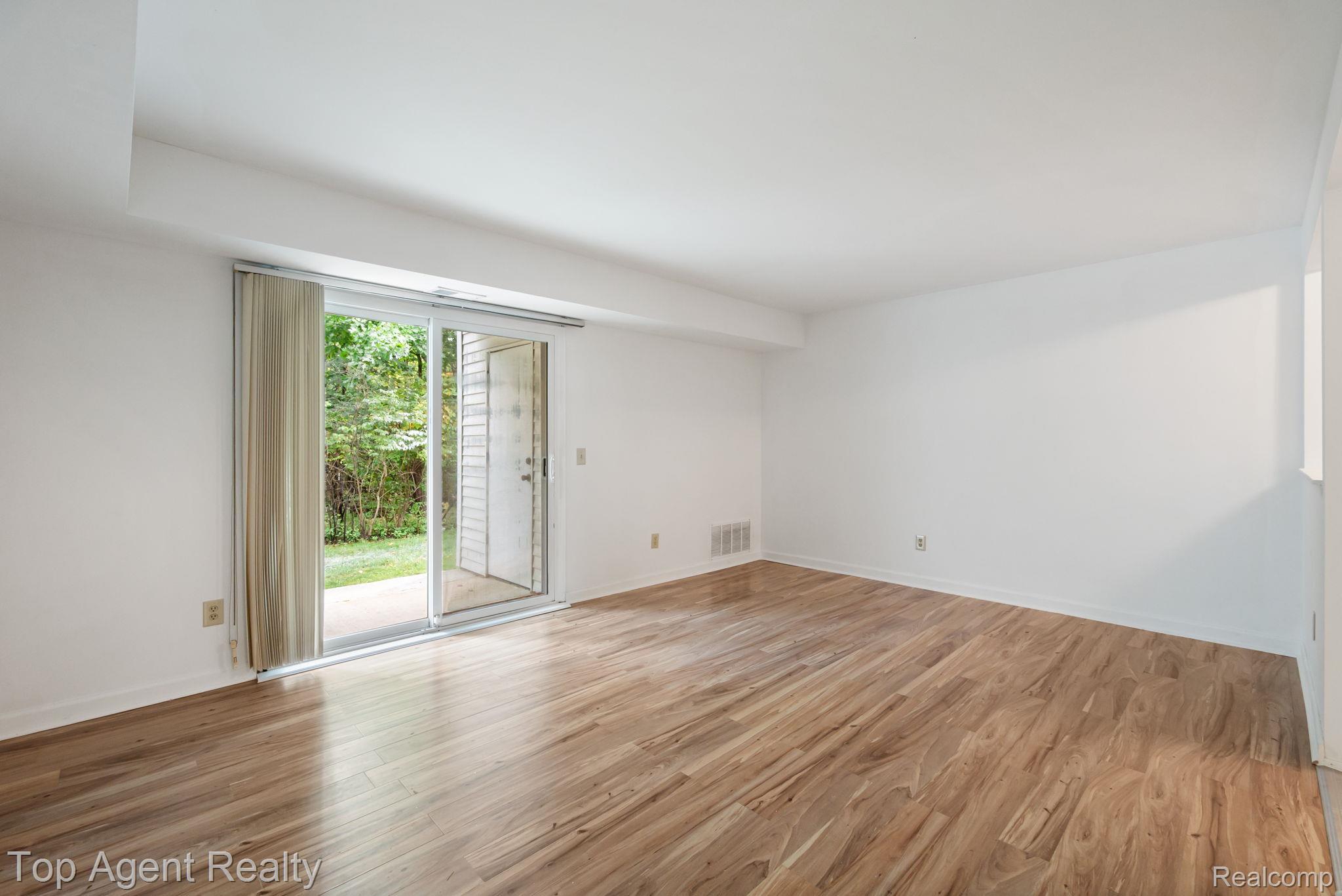 23420 Middlebelt Road Farmington, MI 48336 - Photo 4 of 32 Wood-finish flooring, sliding glass door, white walls, and a recessed ceiling element