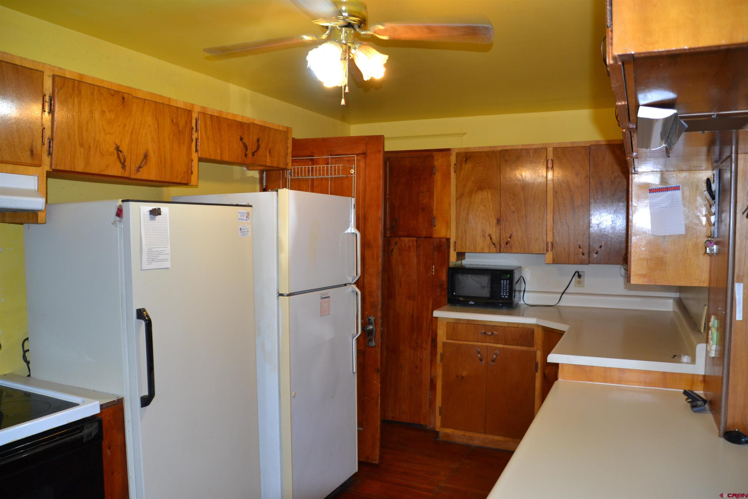21964 Austin Road Austin, CO 81410 - Photo 12 of 33 a white refrigerator freezer and a stove sitting inside of a kitchen
