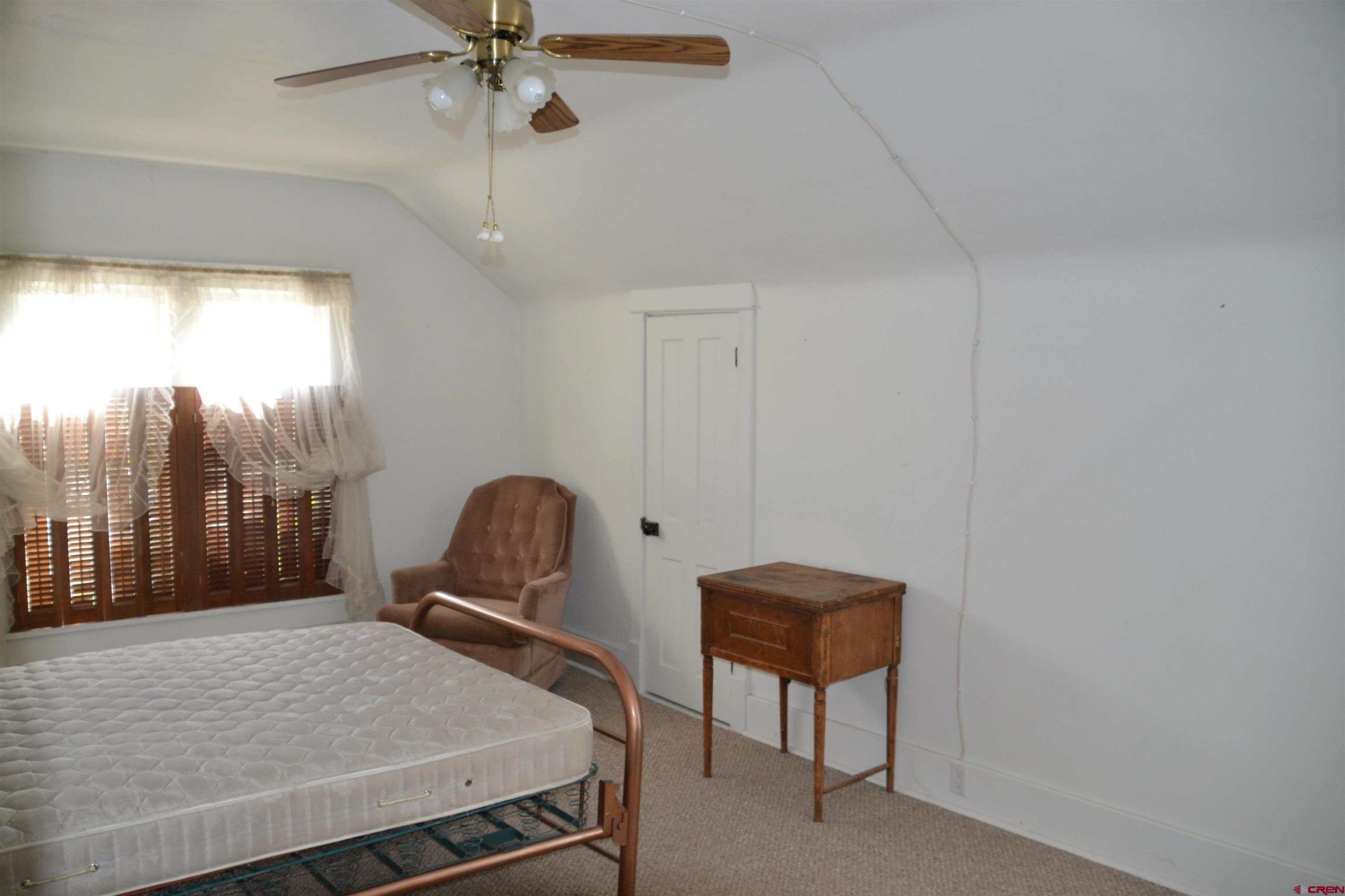 21964 Austin Road Austin, CO 81410 - Photo 22 of 33 a bedroom with a bed and a chandelier