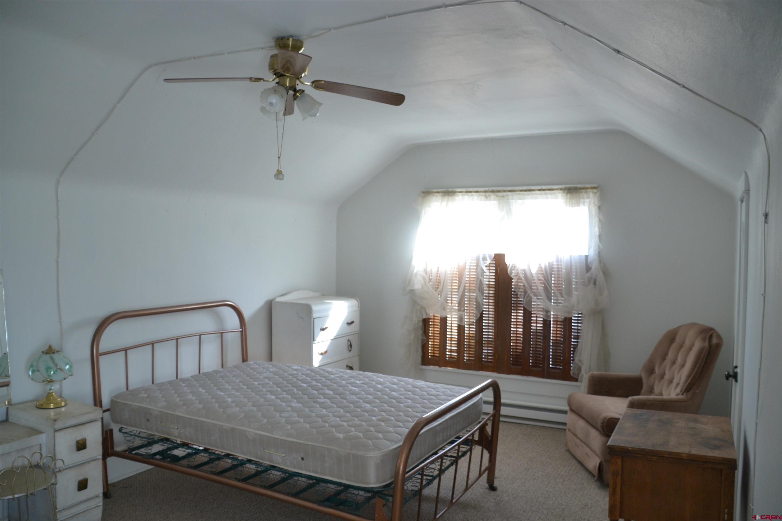 21964 Austin Road Austin, CO 81410 - Photo 23 of 33 a bedroom with furniture and a chandelier