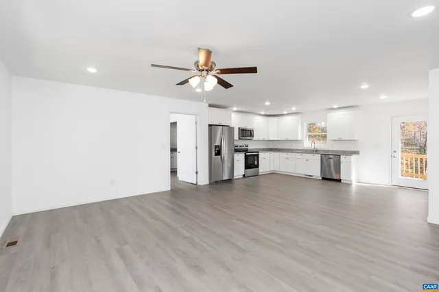 a large kitchen with granite countertop a white stove top oven and cabinets
