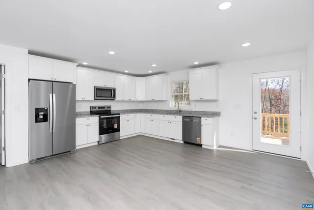 a kitchen with stainless steel appliances kitchen island wooden cabinets and refrigerator