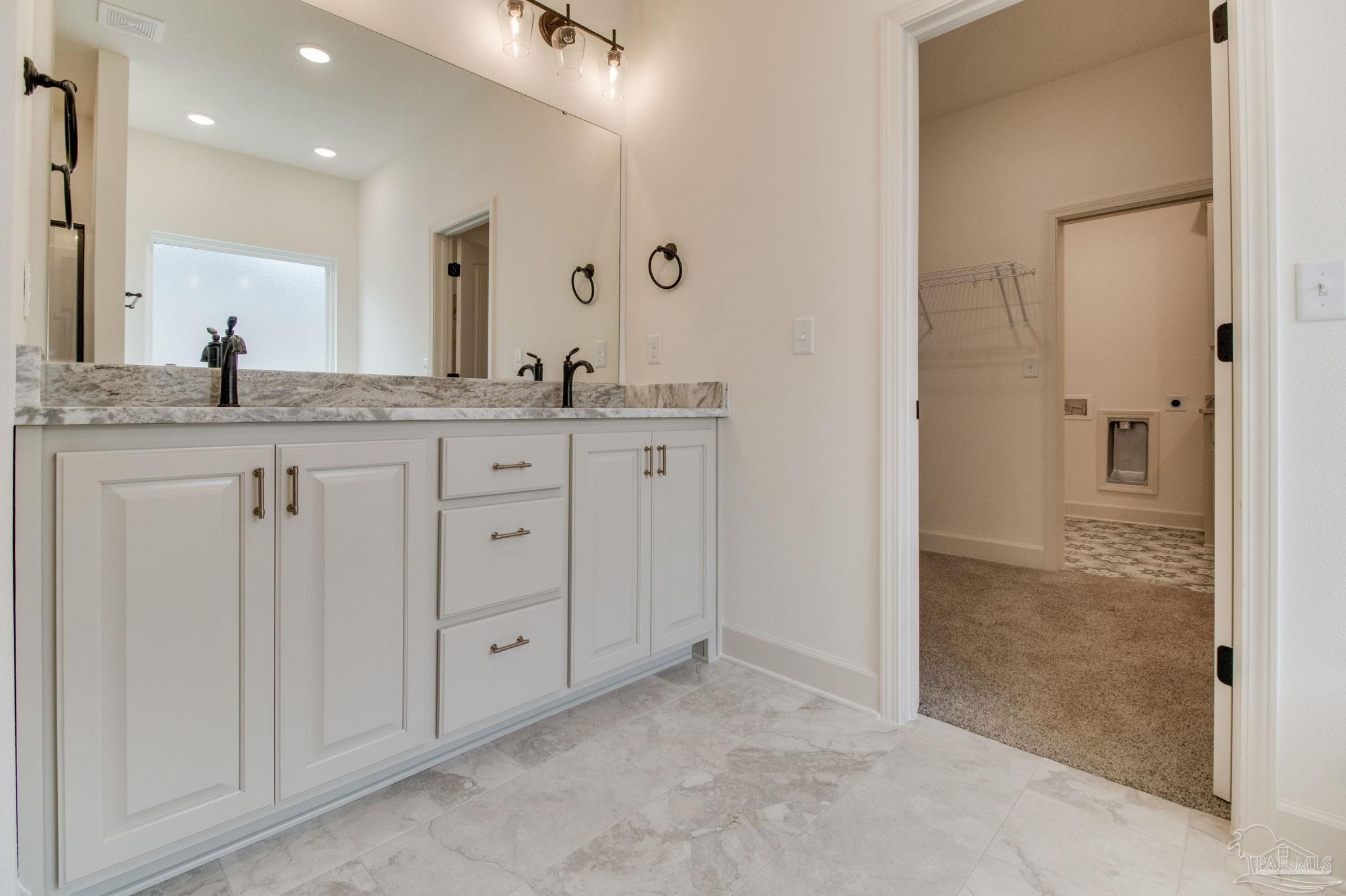 4310 Watkins Street Pace, FL 32571 - Photo 40 of 58 a bathroom with a granite countertop sink two mirror and shower
