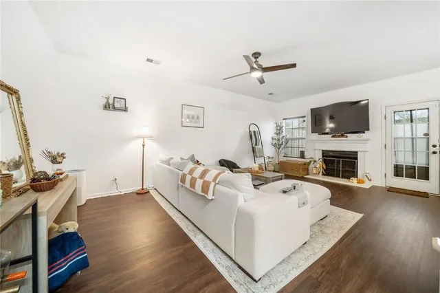 a living room with furniture a flat screen tv and a fireplace