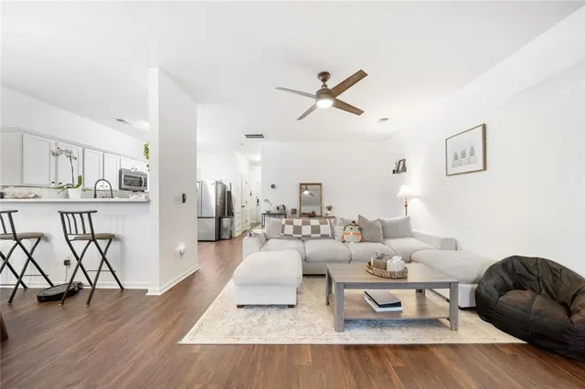 a living room with furniture a flat screen tv and a window
