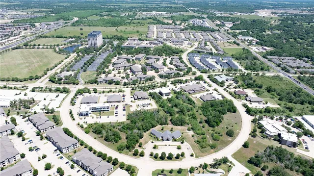 an aerial view of residential houses with outdoor space and trees