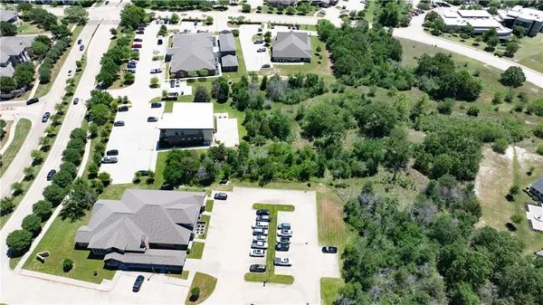 an aerial view of residential houses with outdoor space and trees