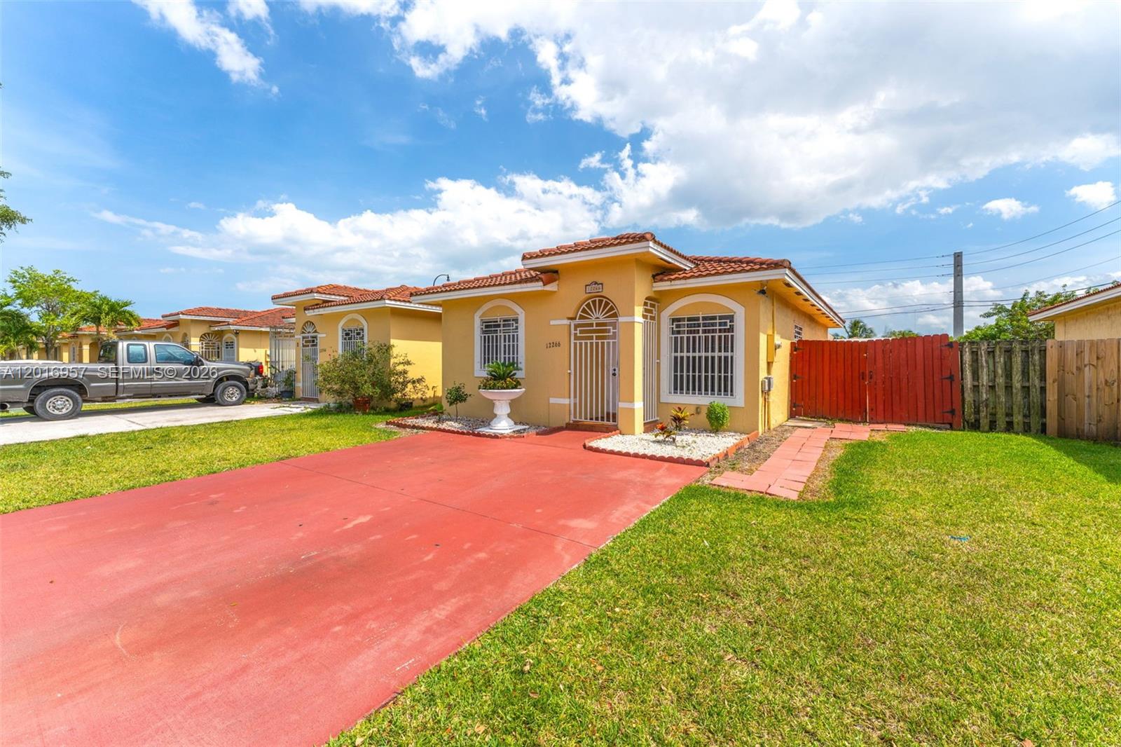 12266 Southwest 215th Terrace Miami, FL 33177 - Photo 1 of 29 a front view of a house with yard and green space