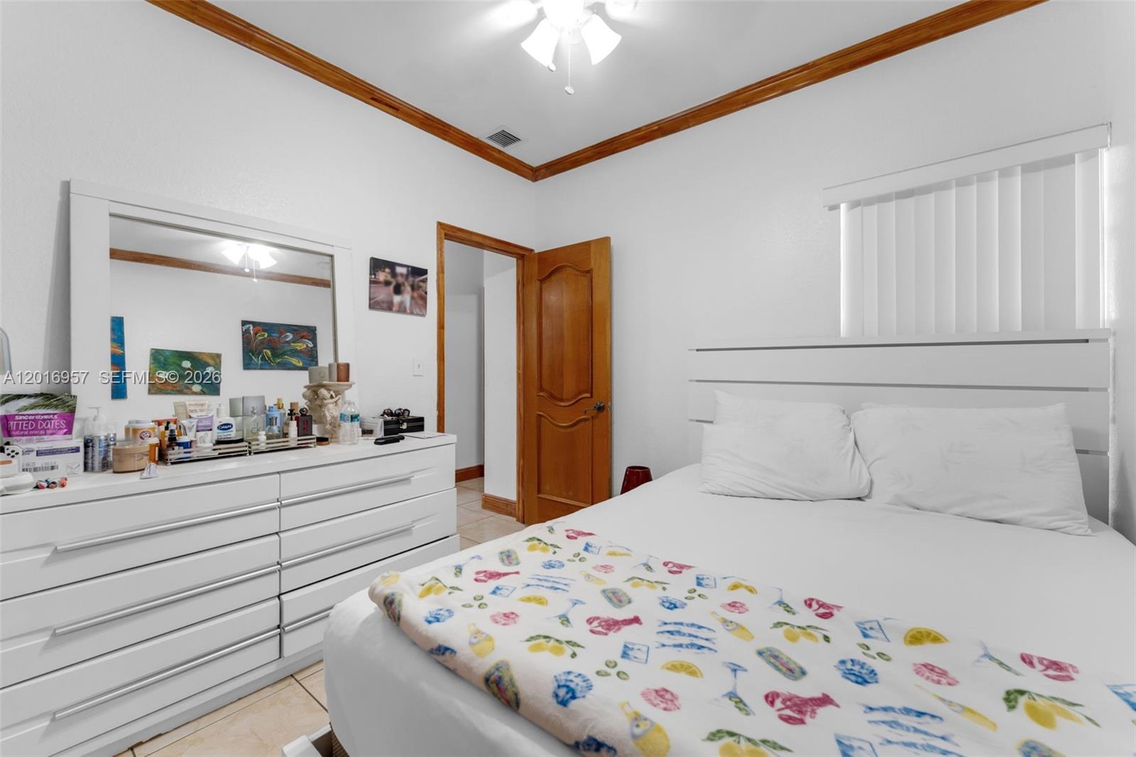 12266 Southwest 215th Terrace Miami, FL 33177 - Photo 14 of 29 a bedroom with a bed and a chandelier
