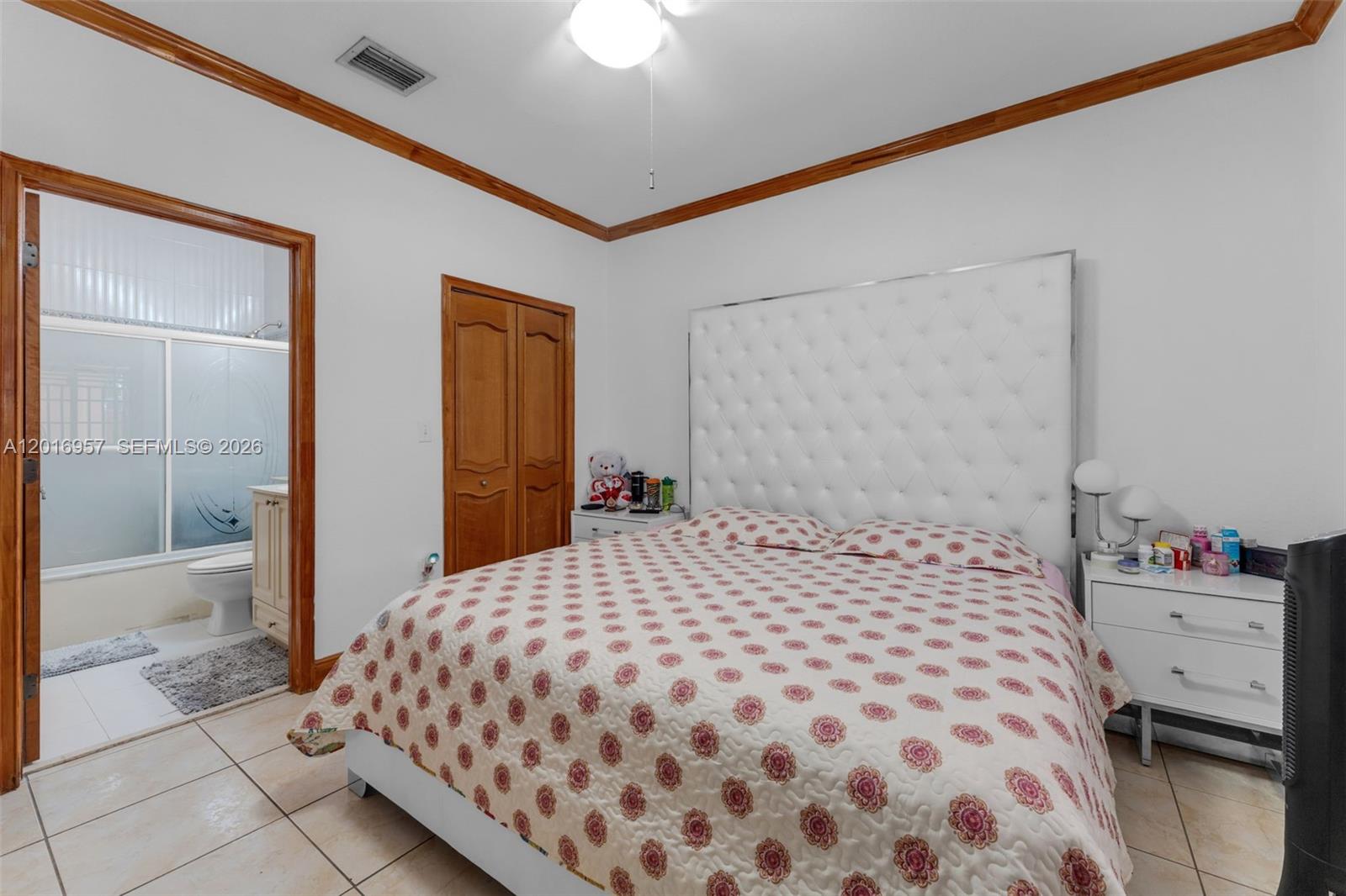12266 Southwest 215th Terrace Miami, FL 33177 - Photo 16 of 29 a bedroom with a large bed and a chandelier