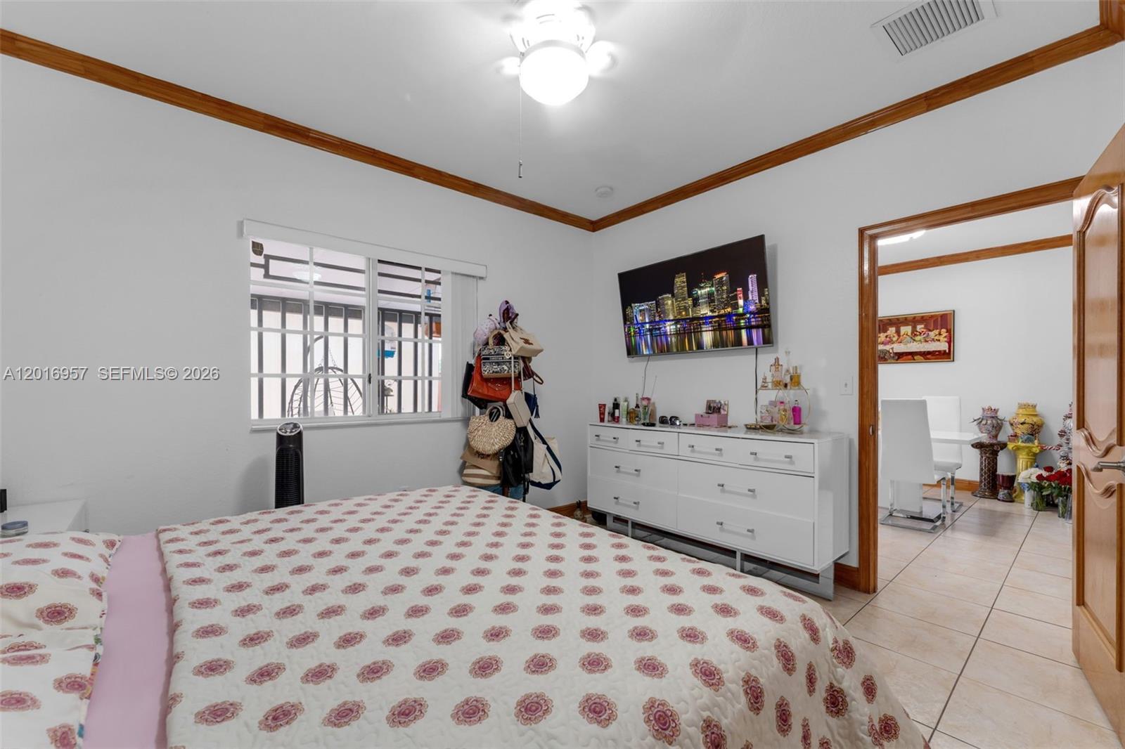 12266 Southwest 215th Terrace Miami, FL 33177 - Photo 18 of 29 a bedroom with a bed and a chandelier
