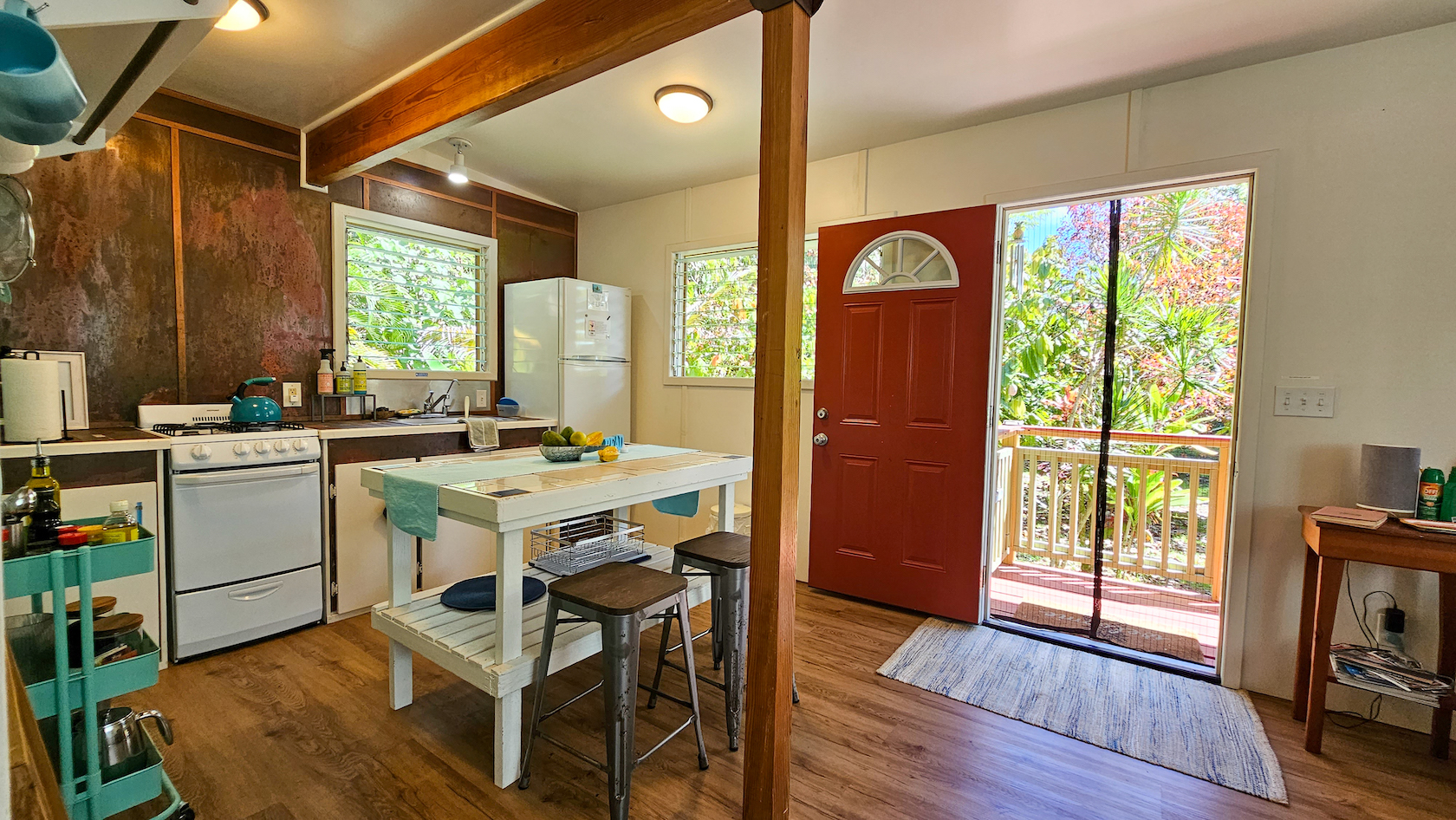 14-249 Pakaka Road Pahoa, HI 96778 - Photo 8 of 29 a kitchen with a refrigerator a stove a sink dishwasher with a dining table and chairs with wooden floor
