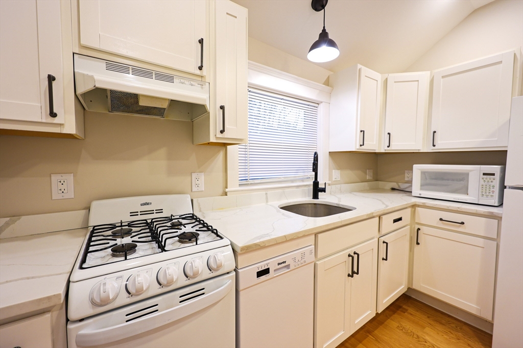 85 Oak Street, Unit 85 Randolph, MA 02368 - Photo 11 of 26 a kitchen with cabinets appliances and a window