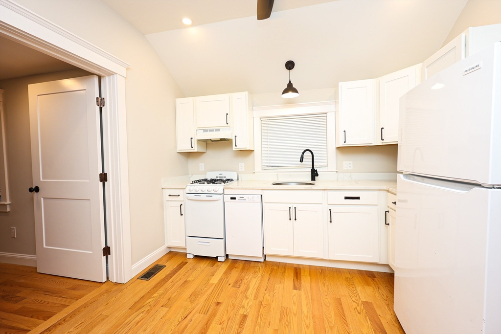 85 Oak Street, Unit 85 Randolph, MA 02368 - Photo 15 of 26 a kitchen with stainless steel appliances a sink stove and white refrigerator with wooden floor