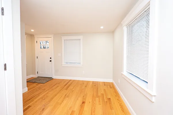 a view of a room with wooden floor and small window