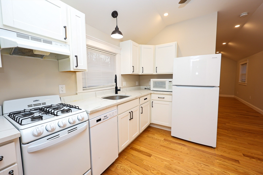85 Oak Street, Unit 85 Randolph, MA 02368 - Photo 21 of 26 a kitchen with white cabinets and white appliances