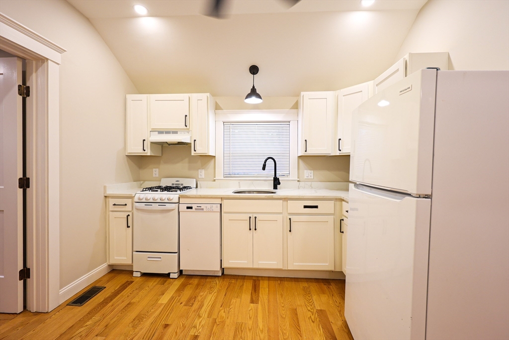 85 Oak Street, Unit 85 Randolph, MA 02368 - Photo 10 of 26 a kitchen with stainless steel appliances a sink and wooden floor