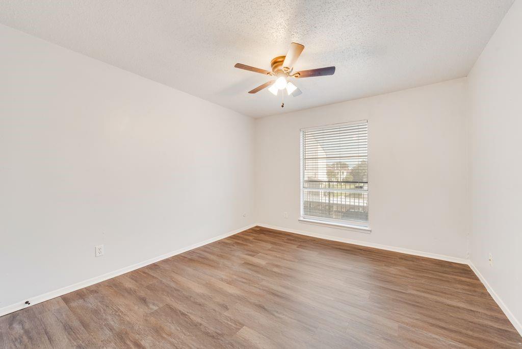 5514 Boca Raton Boulevard, Unit 438 Fort Worth, TX 76112 - Photo 17 of 25 a view of an empty room with wooden floor and a window
