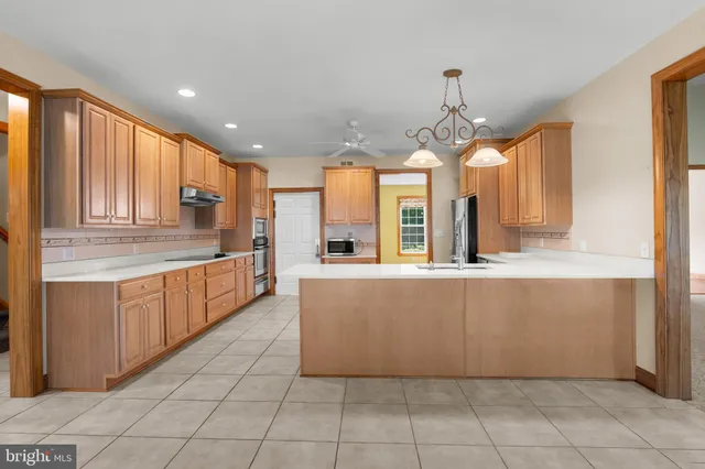 a kitchen with stainless steel appliances granite countertop a sink a stove and a refrigerator