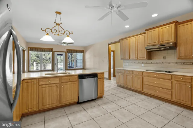 a kitchen with granite countertop a refrigerator and a sink