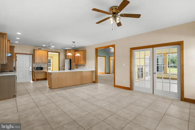 a dining room with wooden floor a chandelier a wooden table and chairs