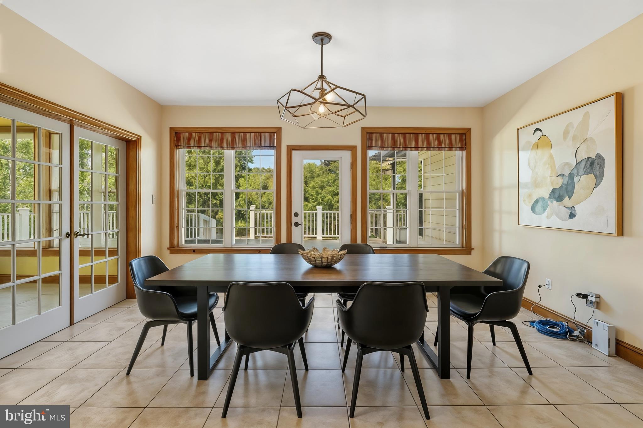 1211 Dexter Corner Road Townsend, DE 19734 - Photo 28 of 66 a dining room with wooden floor a chandelier a wooden table and chairs