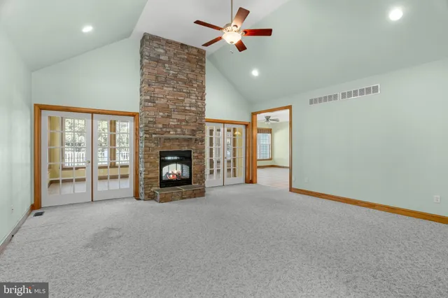 a view of an empty room with a fireplace and a window