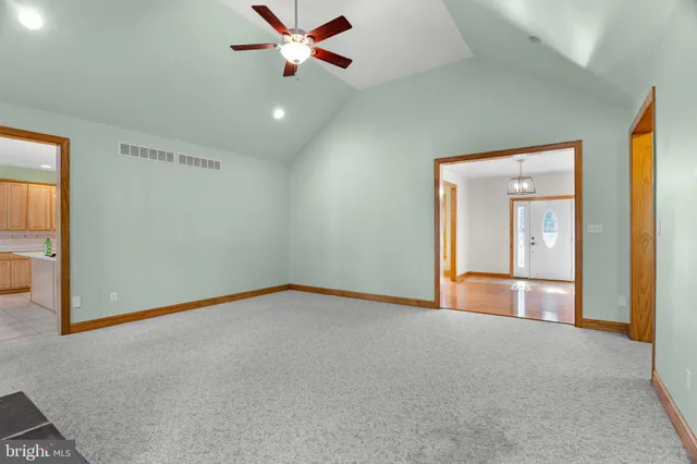 an empty room with windows and ceiling fan
