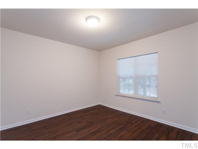 7242 Galon Glen Road Raleigh, NC 27613 - Photo 3 of 17 a view of an empty room with wooden floor and a window
