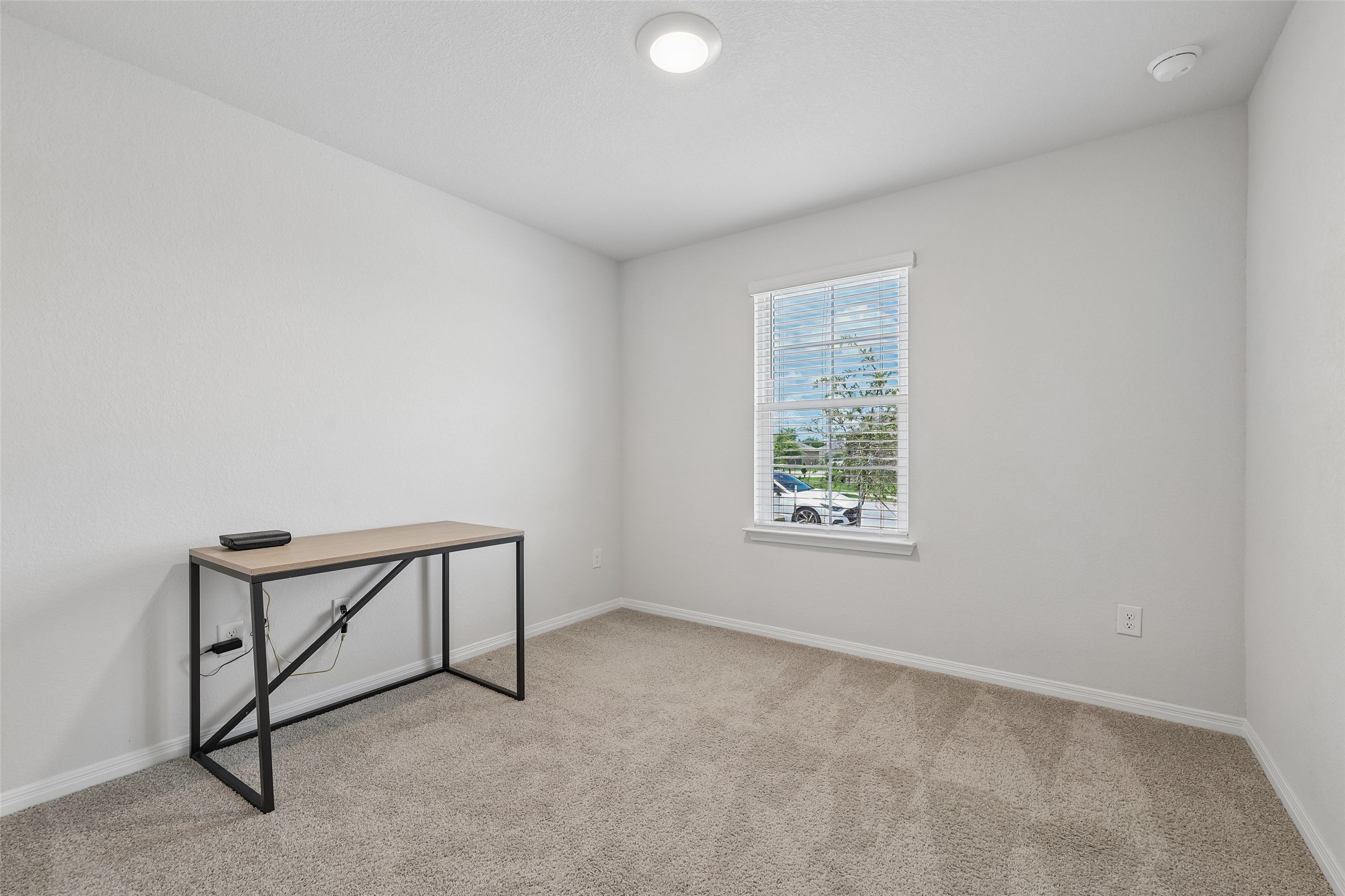 19805 Abigail Fillmore Road Manor, TX 78653 - Photo 21 of 40 A well-lit, neutral-toned room features soft carpeting and a window for natural illumination.
