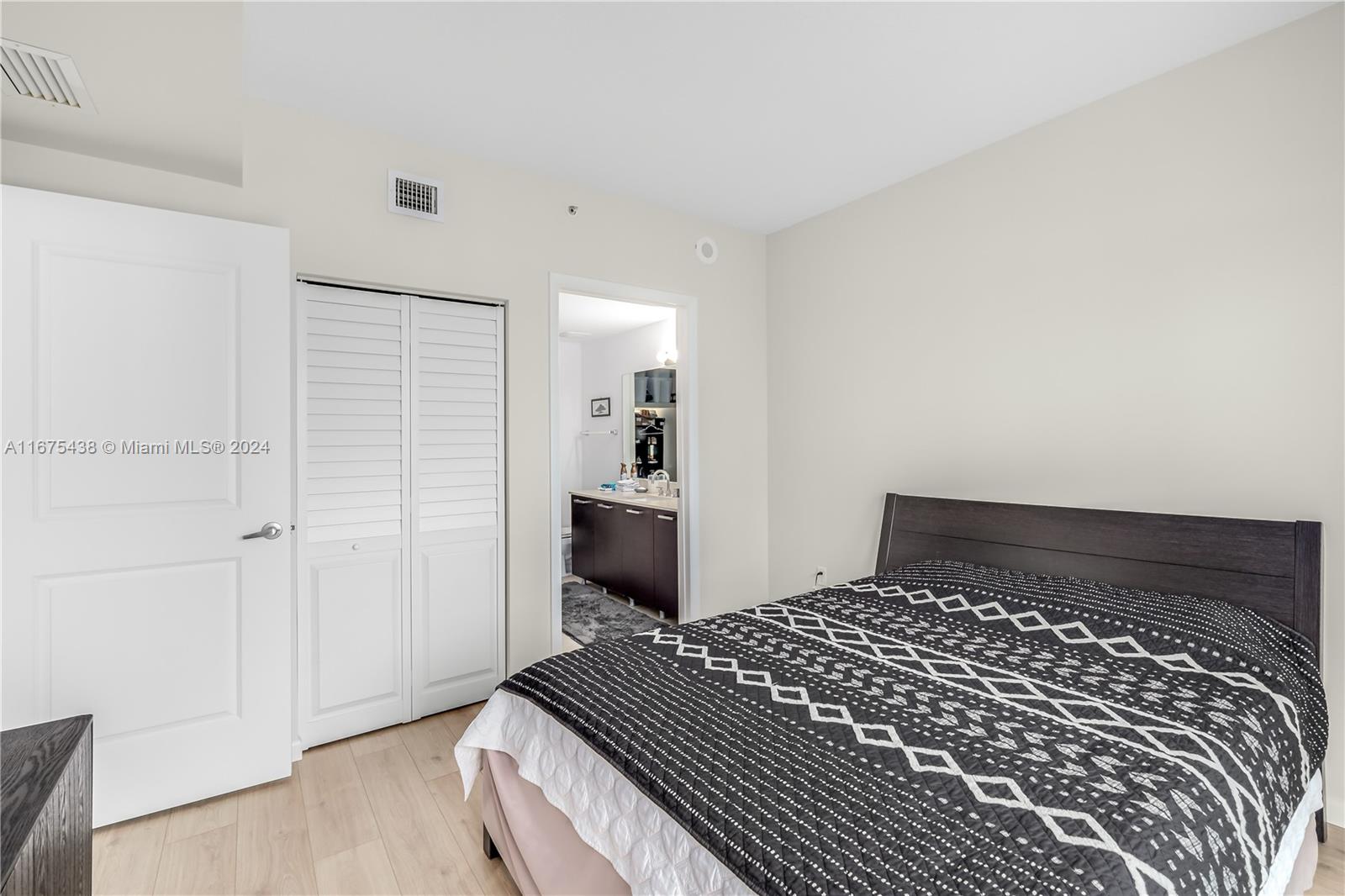 333 Northeast 24th Street, Unit 1206 Miami, FL 33137 - Photo 12 of 26 a bedroom with a bed and wooden floor