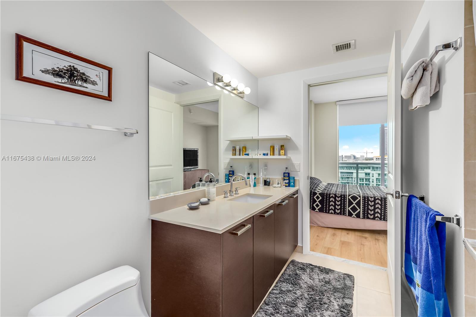 333 Northeast 24th Street, Unit 1206 Miami, FL 33137 - Photo 13 of 26 a bathroom with a sink a mirror and a toilet