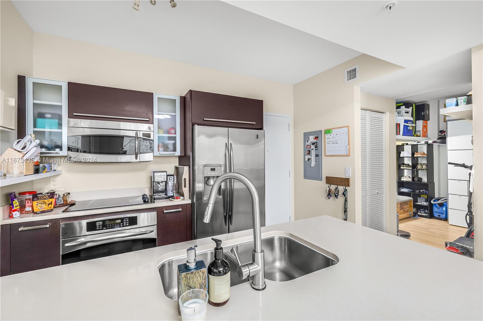 333 Northeast 24th Street, Unit 1206 Miami, FL 33137 - Photo 10 of 26 a kitchen with stainless steel appliances a sink a stove and a refrigerator with wooden floor