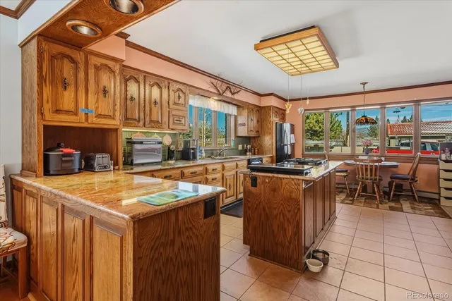 a room with stainless steel appliances lots of counter space and furniture