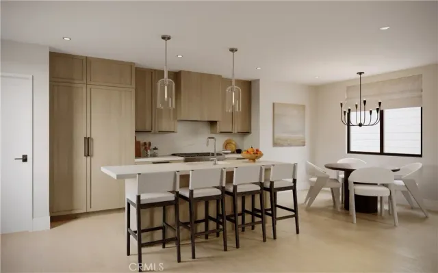a kitchen with kitchen island a dining table chairs and white cabinets