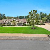 a front view of a house with a yard and trees